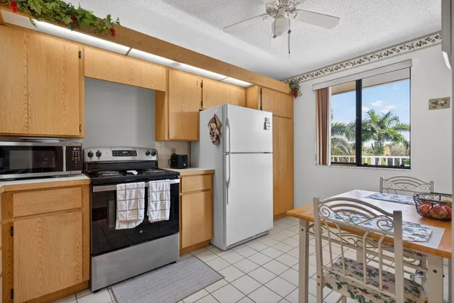 a kitchen with stainless steel appliances granite countertop a refrigerator a stove and a sink
