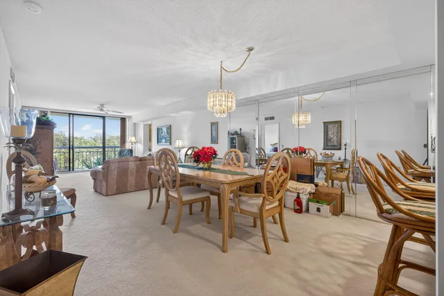 a living room with furniture a floor to ceiling window and a rug