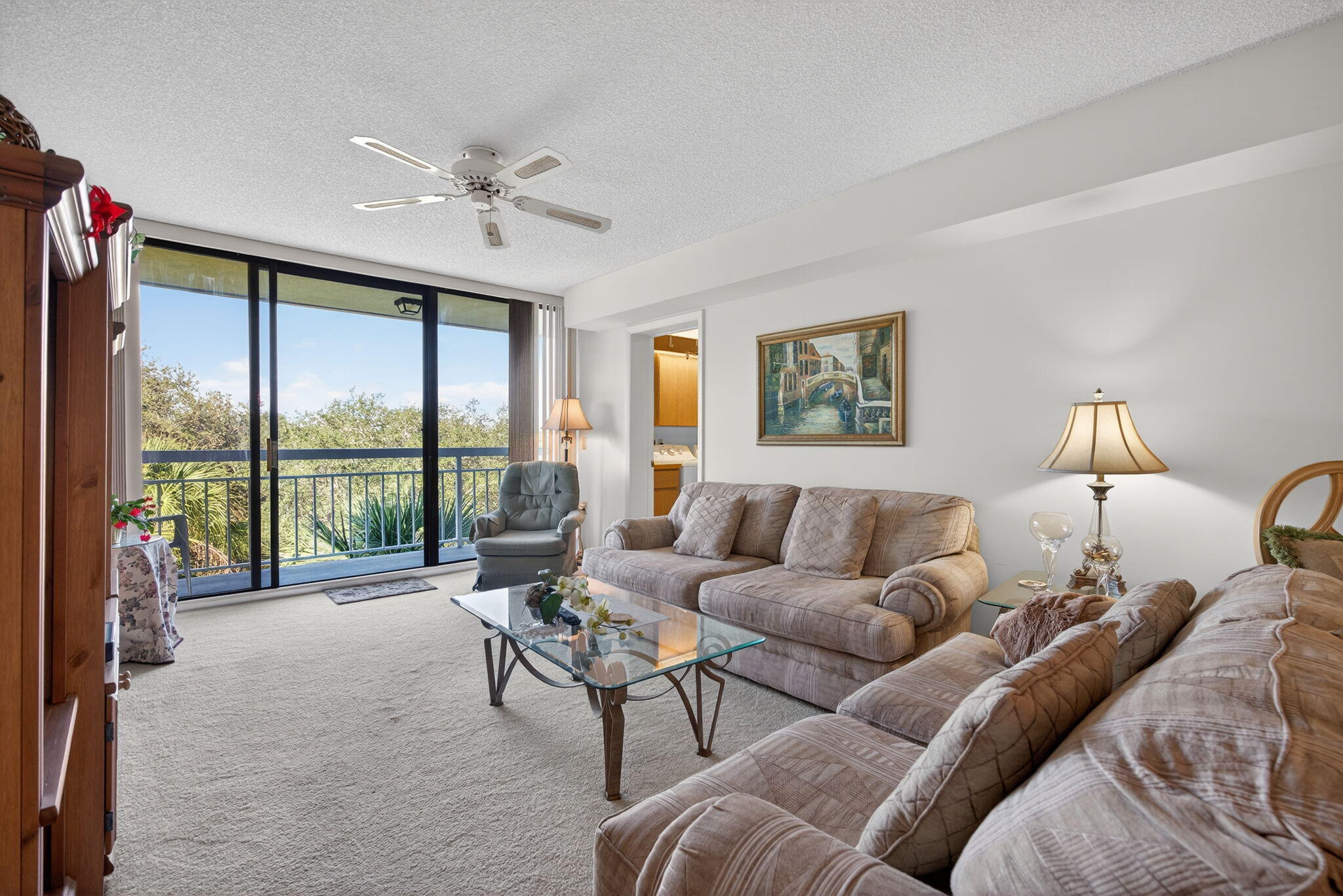 2581 Village Boulevard, Unit 401 West Palm Beach, FL 33409 - Photo 8 of 24 a living room with furniture and a large window with balcony view