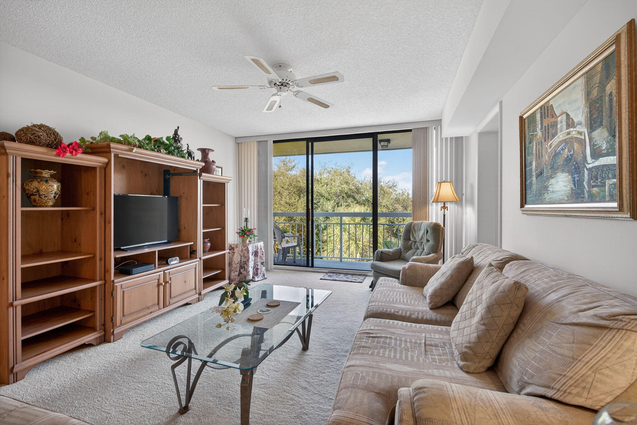 2581 Village Boulevard, Unit 401 West Palm Beach, FL 33409 - Photo 9 of 24 a living room with furniture and a flat screen tv