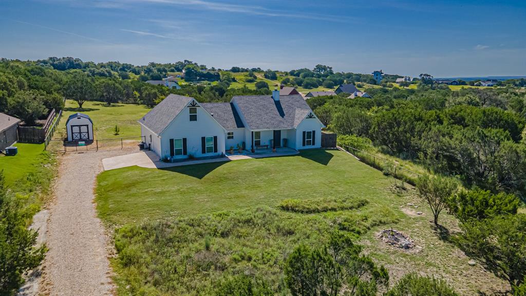 an aerial view of residential houses with outdoor space and trees