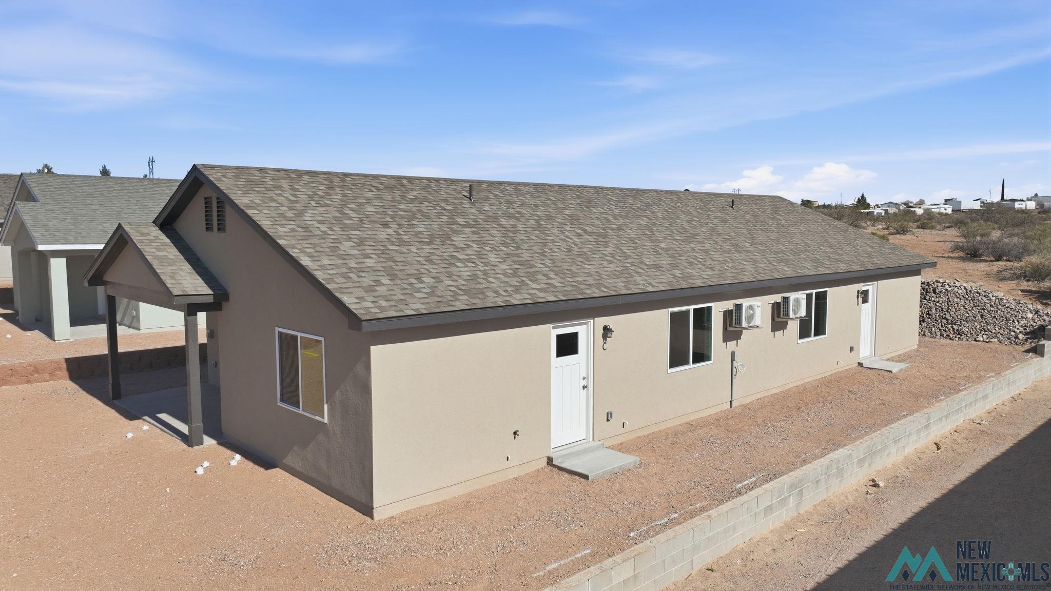 106 Inca Street Elephant Butte, NM 87935 - Photo 4 of 36 View of front facade featuring roof with shingles and stucco siding