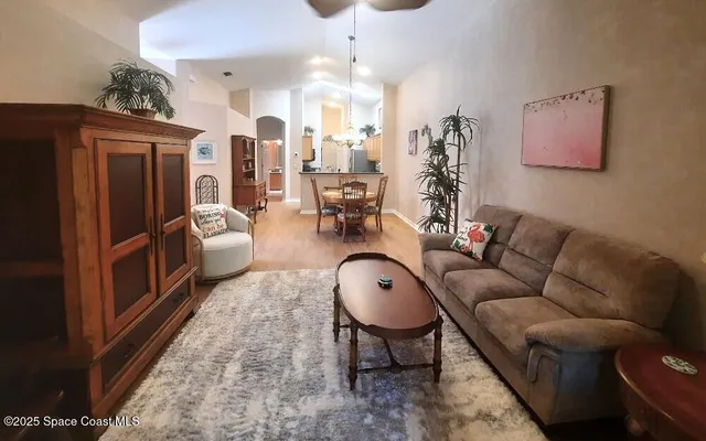 a living room with furniture a chandelier and a rug