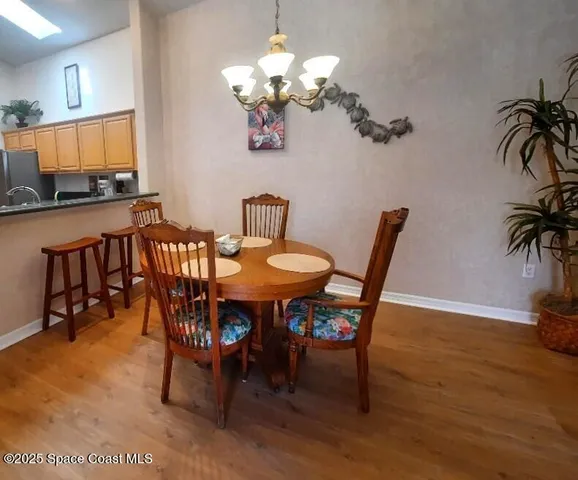 a dining room with furniture potted plants and wooden floor