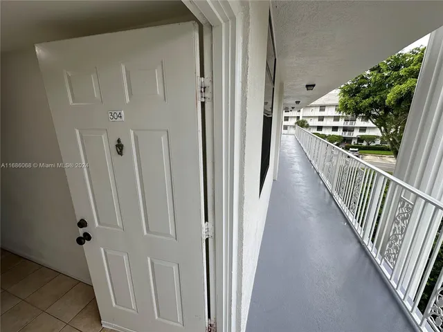a view of a hallway with wooden floor and stairs