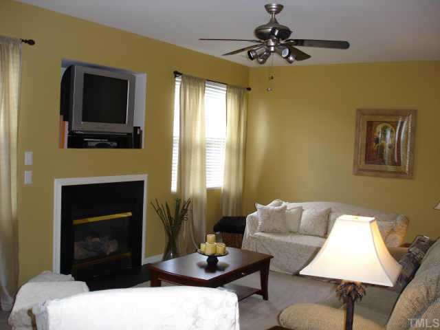 5412 Glass Ridge Road Raleigh, NC 27616 - Photo 3 of 12 a living room with furniture a fireplace and a flat screen tv