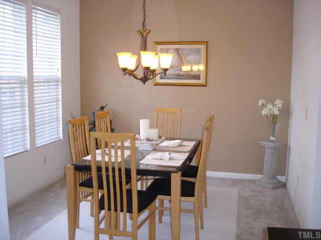 5412 Glass Ridge Road Raleigh, NC 27616 - Photo 6 of 12 a view of a dining room with furniture a chandelier and wooden floor