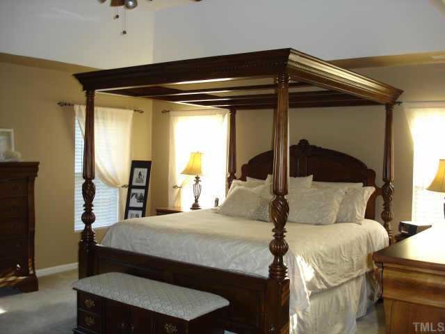 5412 Glass Ridge Road Raleigh, NC 27616 - Photo 7 of 12 a bedroom with a bed and a mirror