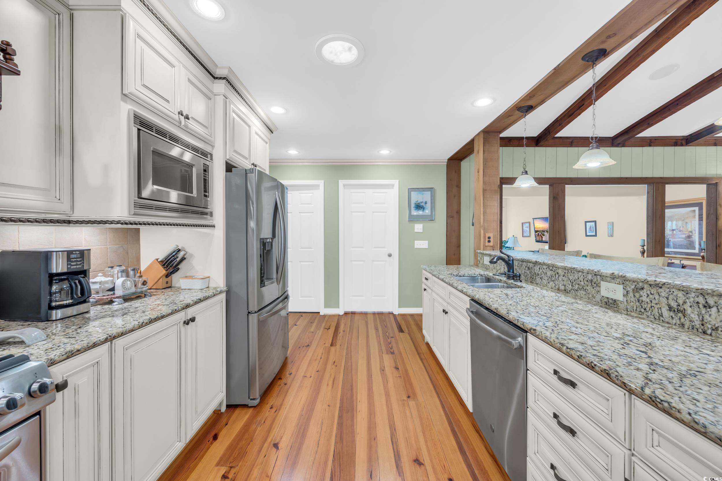 855 Riven Oak Drive Murrells Inlet, SC 29576 - Photo 11 of 37 Kitchen featuring light stone counters, white cabinetry, pendant lighting, stainless steel appliances, and light wood-type flooring