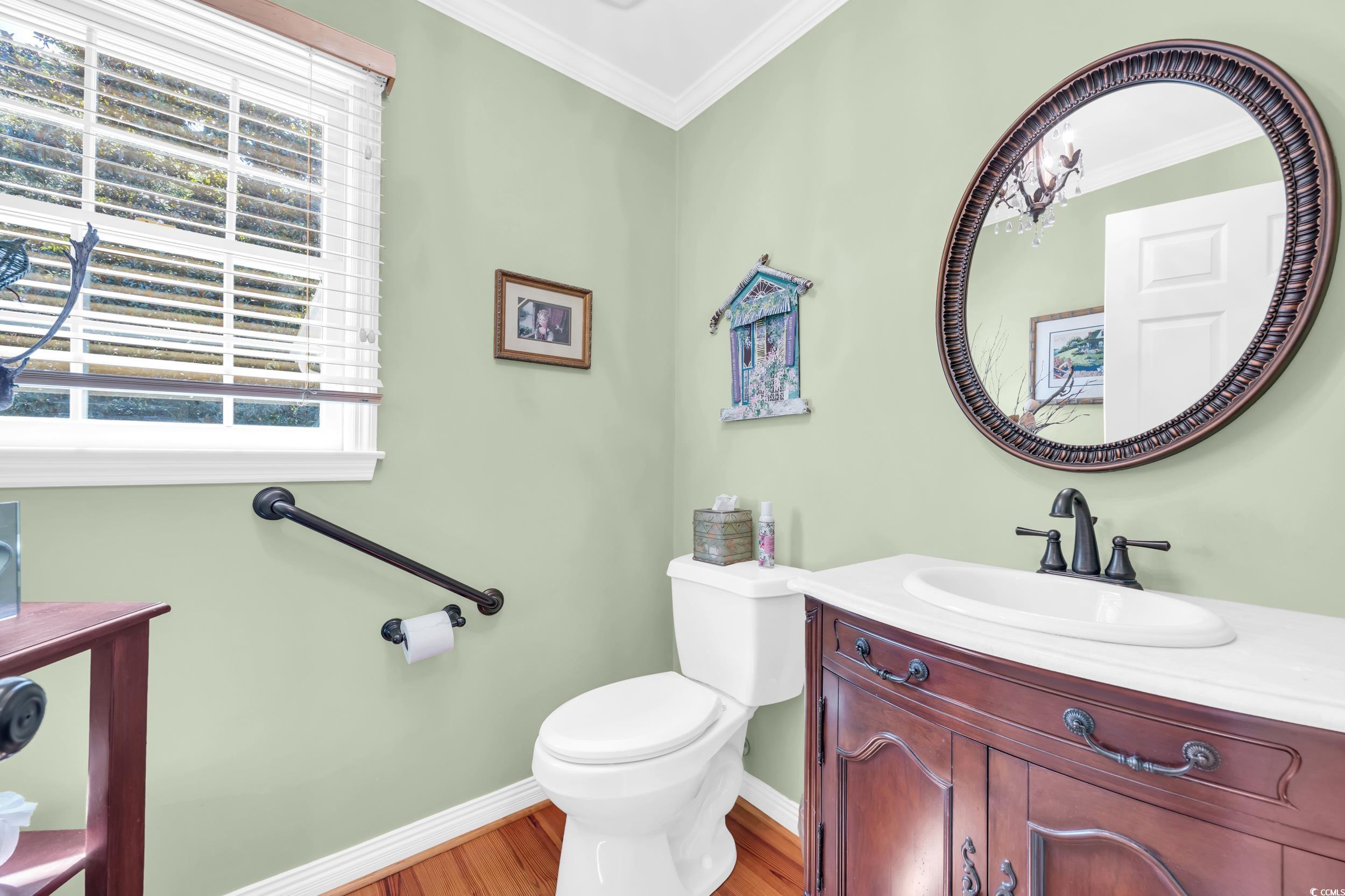 855 Riven Oak Drive Murrells Inlet, SC 29576 - Photo 12 of 37 Half bathroom with crown molding, vanity, and light wood-type flooring