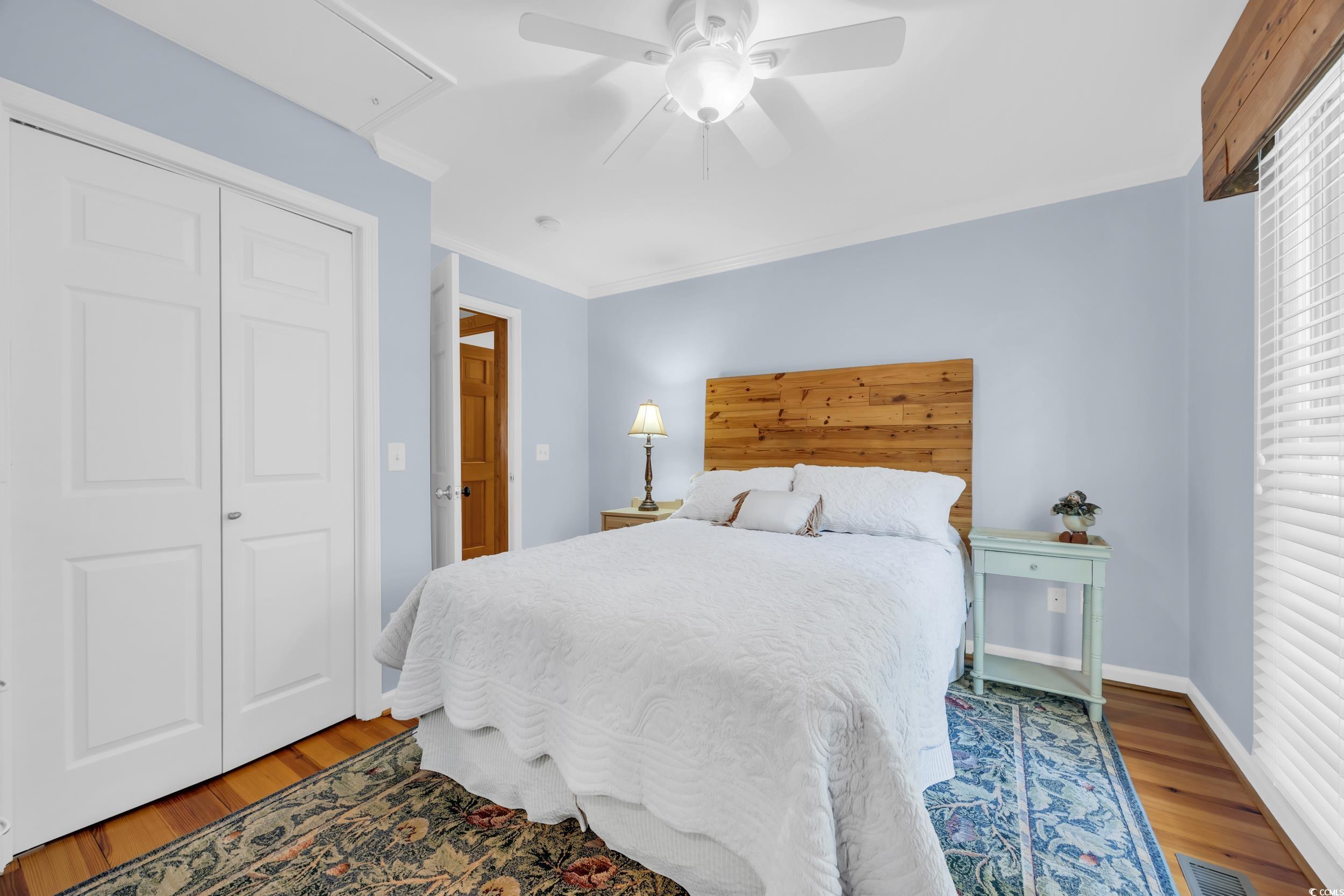 855 Riven Oak Drive Murrells Inlet, SC 29576 - Photo 15 of 37 Bedroom featuring attic access, wood finished floors, a closet, crown molding, and ceiling fan