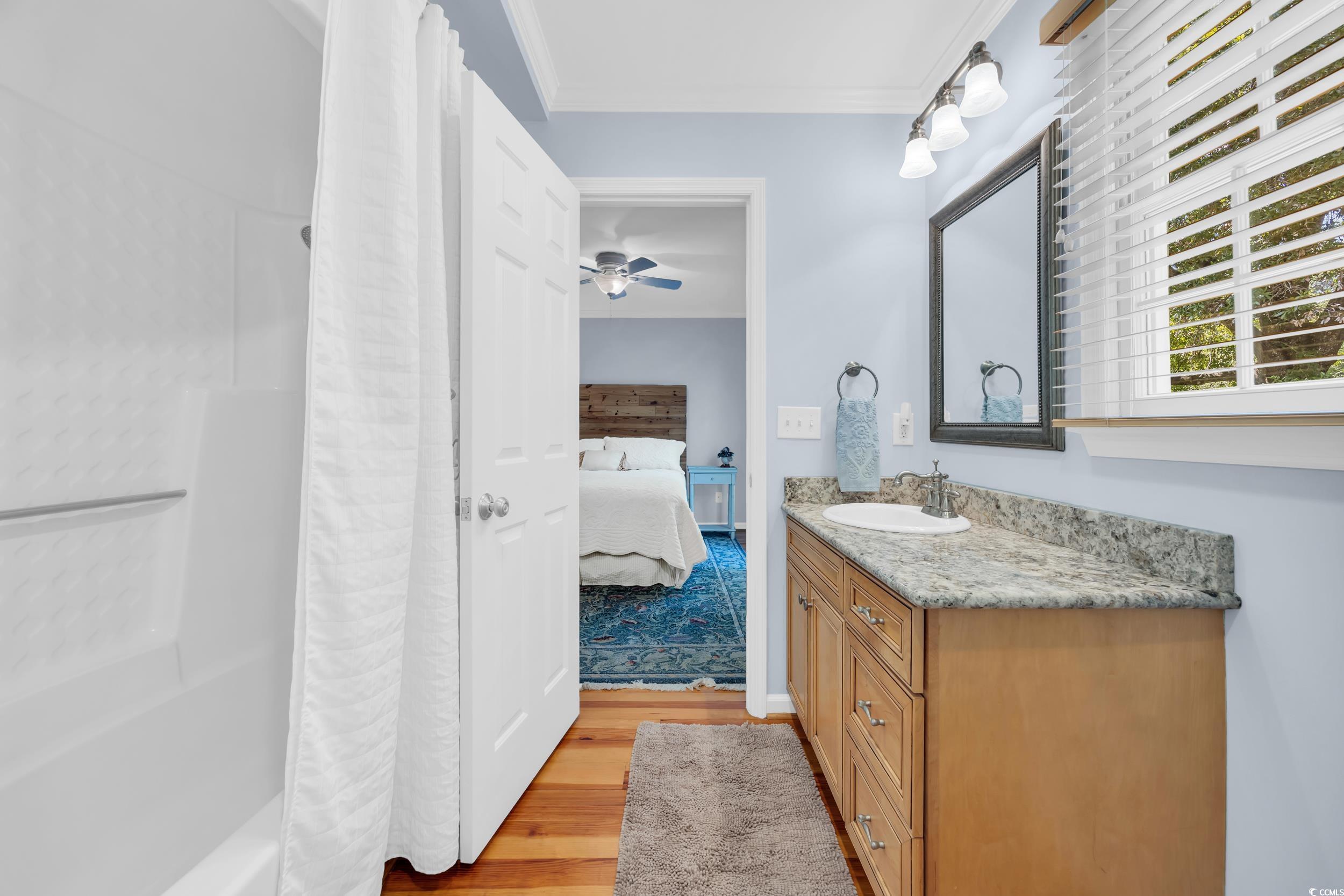 855 Riven Oak Drive Murrells Inlet, SC 29576 - Photo 17 of 37 Ensuite bathroom featuring light wood finished floors, vanity, crown molding, shower / bath combo with shower curtain, and ceiling fan