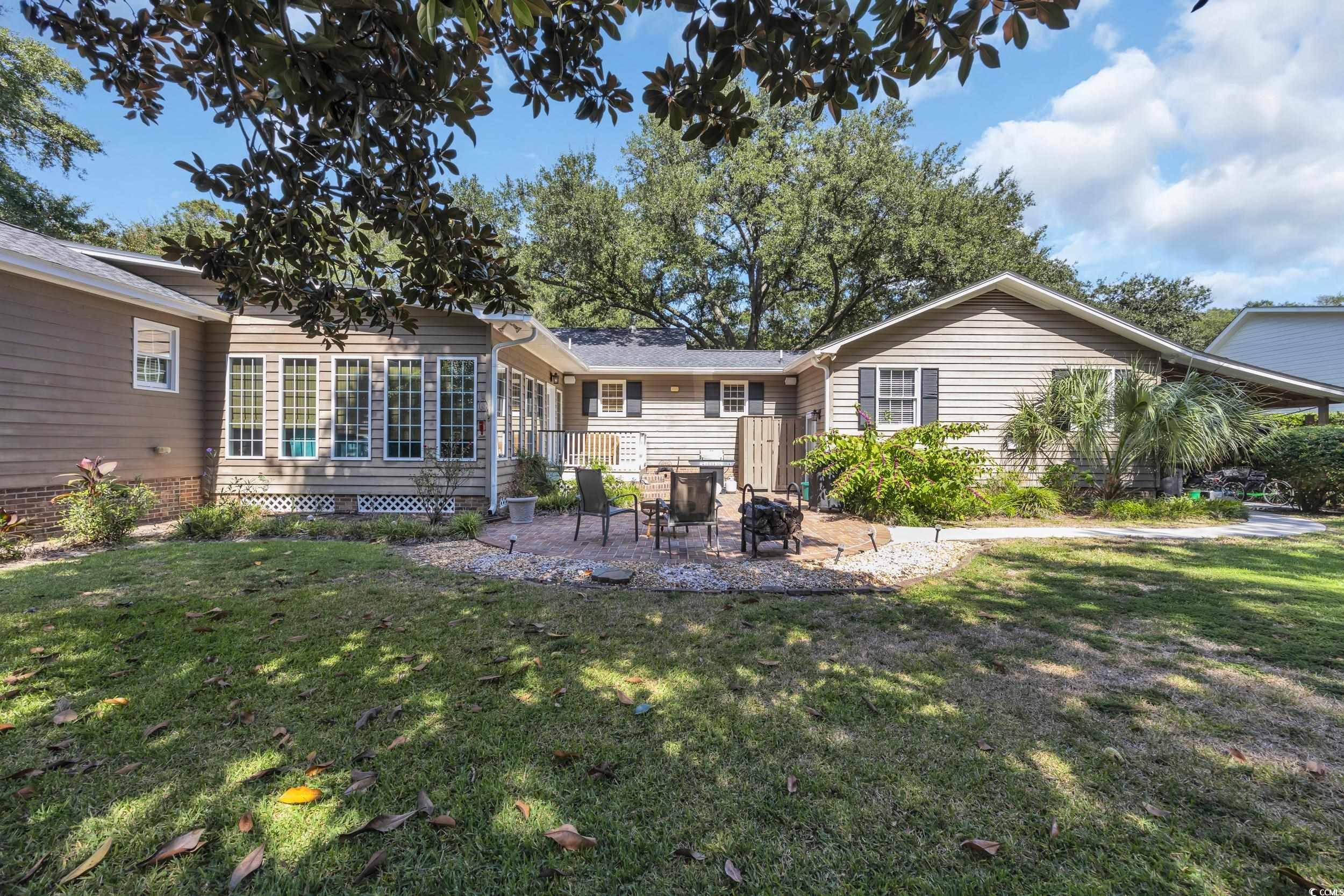 855 Riven Oak Drive Murrells Inlet, SC 29576 - Photo 33 of 37 Back of house featuring a patio area, a lawn, and an outdoor fire pit