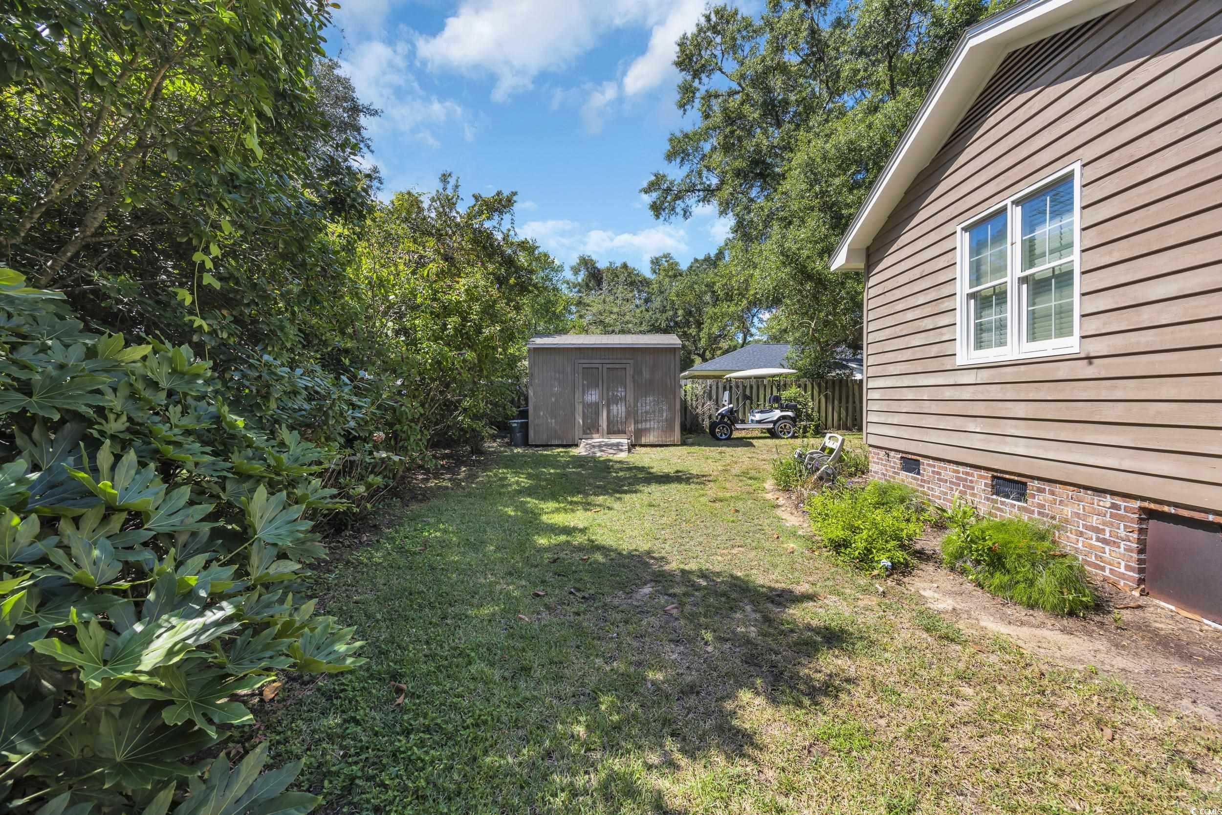 855 Riven Oak Drive Murrells Inlet, SC 29576 - Photo 36 of 37 View of grassy yard featuring a storage shed and a sunroom