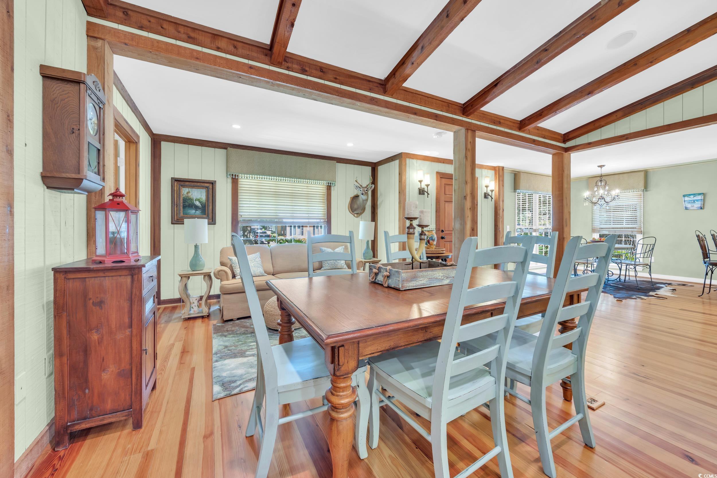 855 Riven Oak Drive Murrells Inlet, SC 29576 - Photo 5 of 37 Dining area featuring light wood finished floors, a chandelier, wood walls, and crown molding