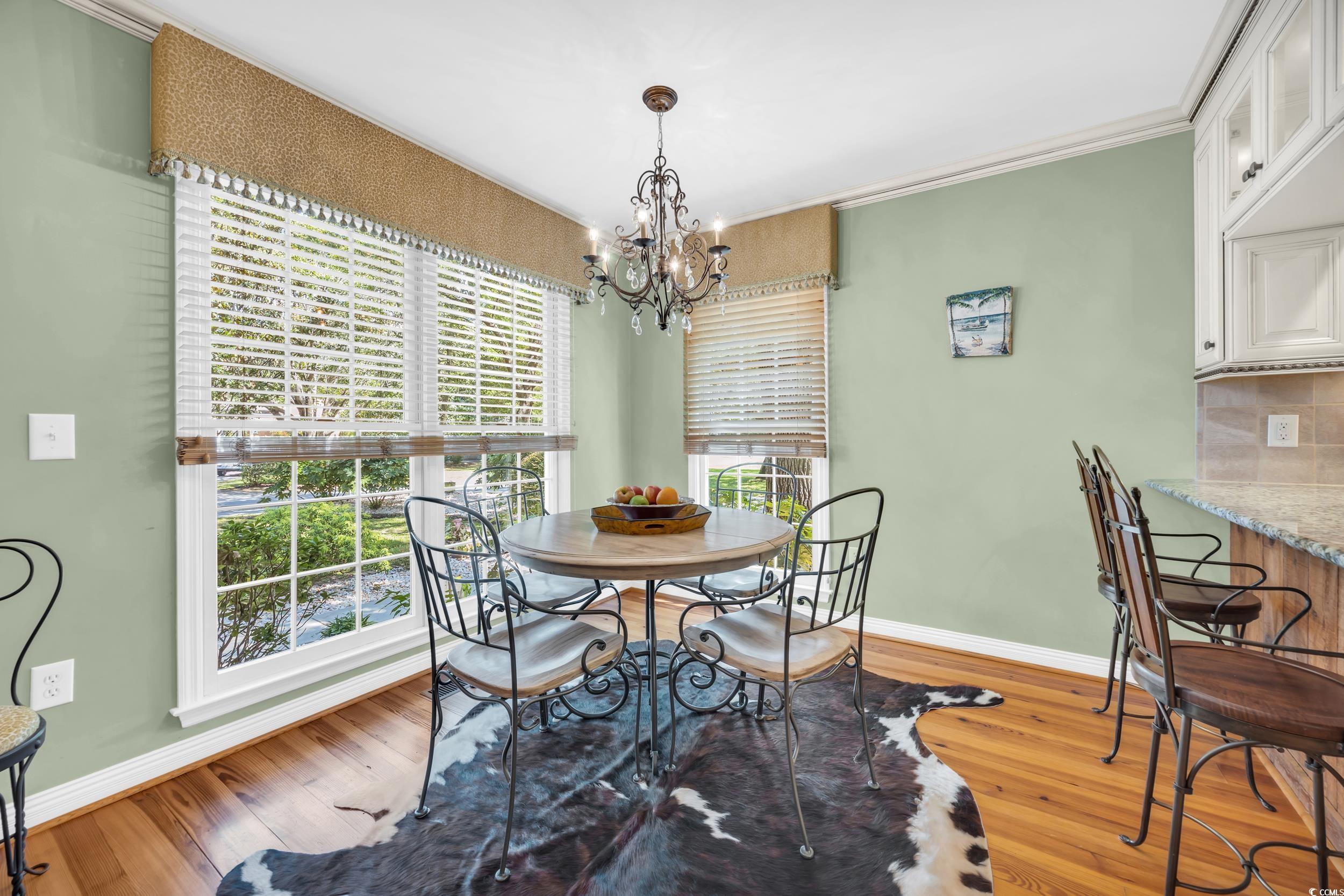 855 Riven Oak Drive Murrells Inlet, SC 29576 - Photo 8 of 37 Dining room featuring light wood-style floors, ornamental molding, and a chandelier