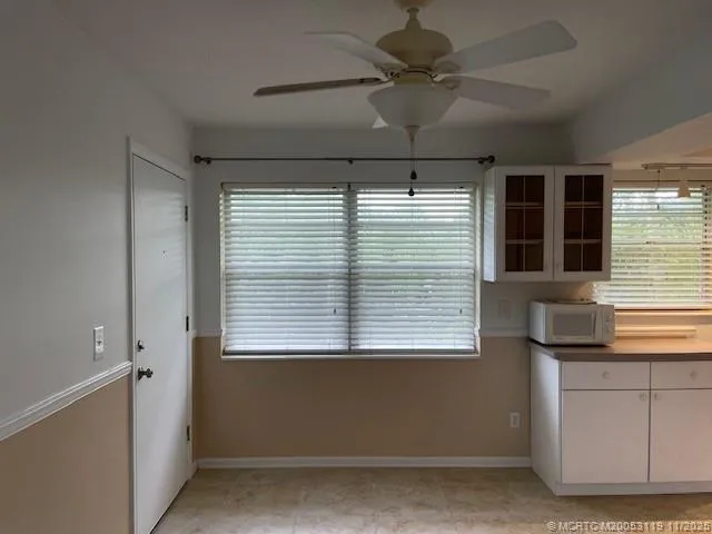 a kitchen with granite countertop white cabinets and window