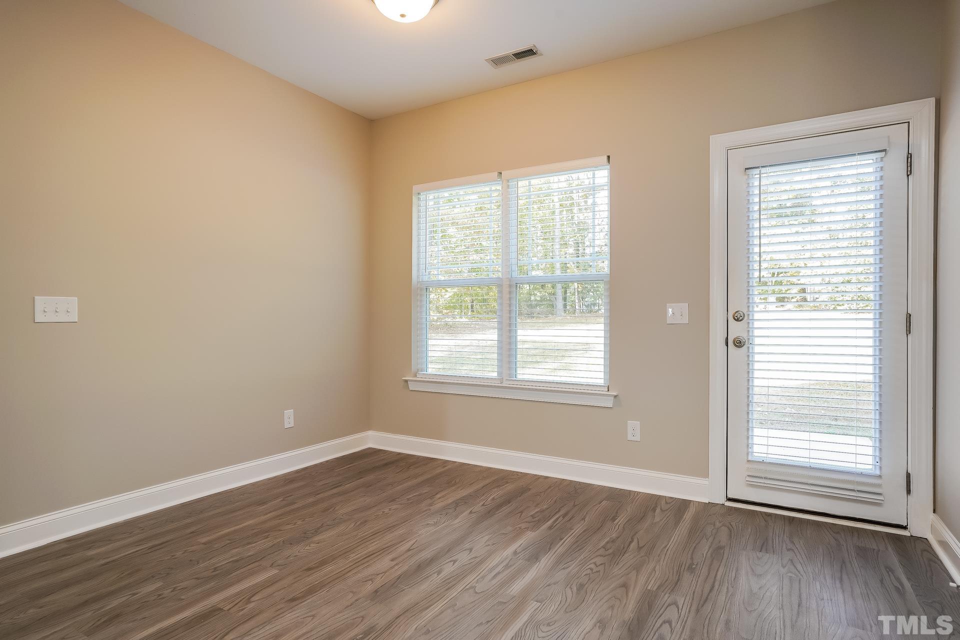 49 Burrage Drive Angier, NC 27501 - Photo 6 of 17 an empty room with wooden floor and windows