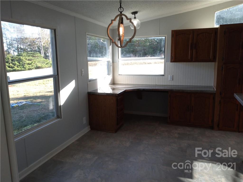 245 Roy Goins Road Rutherfordton, NC 28139 - Photo 11 of 23 a kitchen with a window wooden cabinets and outdoor space