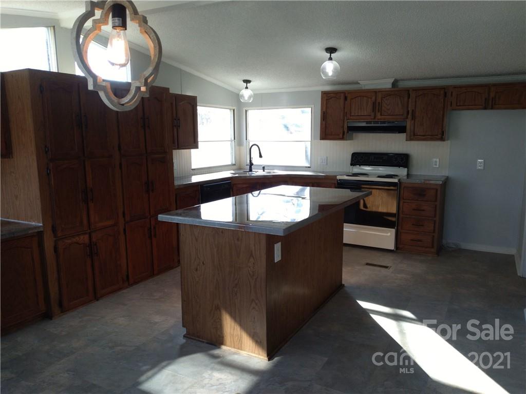 245 Roy Goins Road Rutherfordton, NC 28139 - Photo 10 of 23 a kitchen with granite countertop a stove and a sink