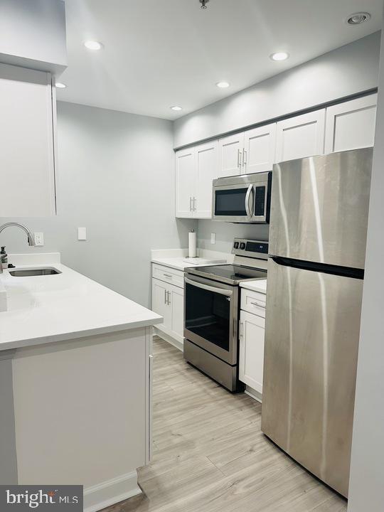 1308 Clifton Street Northwest, Unit 105 Washington, DC 20009 - Photo 5 of 21 a kitchen with stainless steel appliances a refrigerator sink and microwave