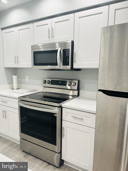 1308 Clifton Street Northwest, Unit 105 Washington, DC 20009 - Photo 6 of 21 a kitchen with stainless steel appliances white cabinets and a refrigerator