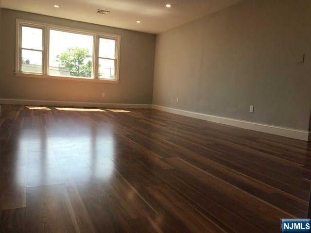 140 Prospect Street, Unit 2 Garfield, NJ 07026 - Photo 4 of 12 an empty room with wooden floor and windows