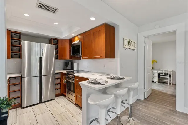 a kitchen with stainless steel appliances granite countertop a refrigerator sink and cabinets