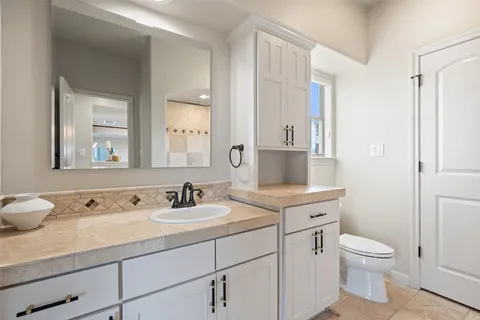 a bathroom with a toilet sink and mirror
