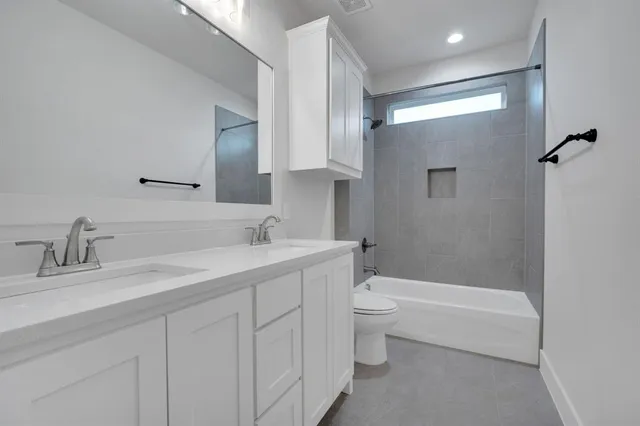 a bathroom with a bathtub shower sink vanity and toilet