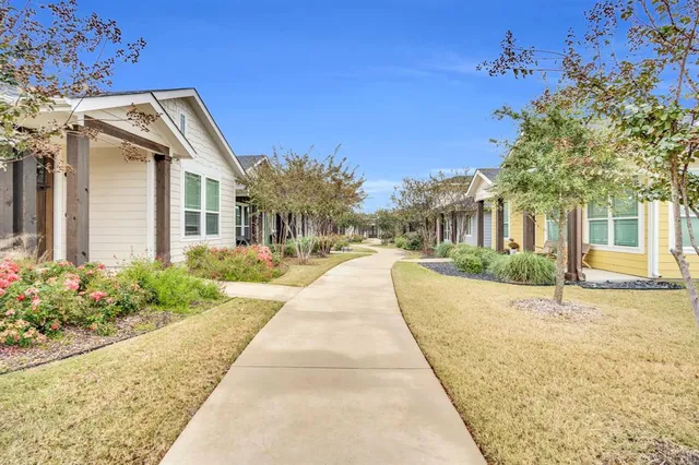 a view of a white building next to a yard
