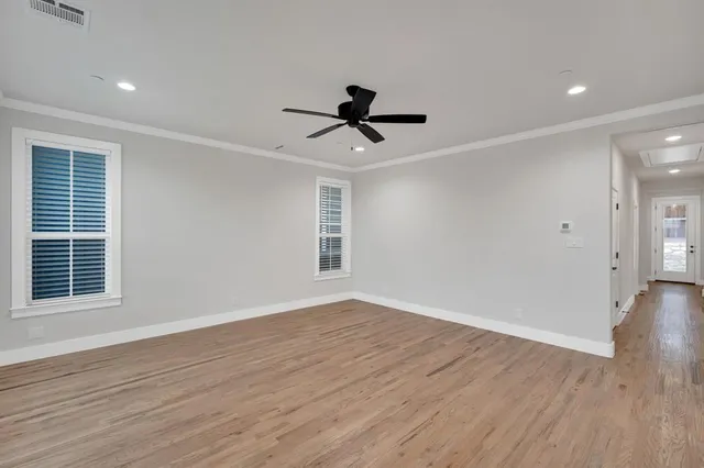 a view of a room with wooden floor and a ceiling fan