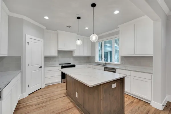 a kitchen with a stove sink and cabinets