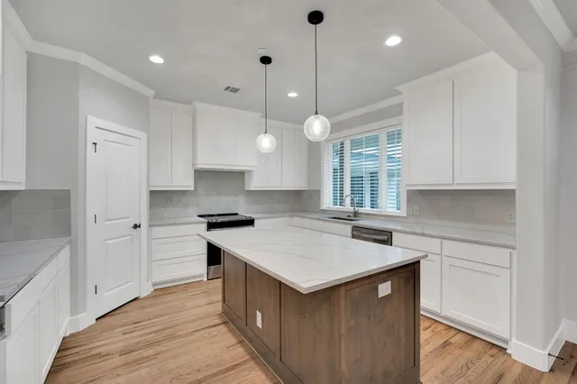 a kitchen with a stove sink and cabinets