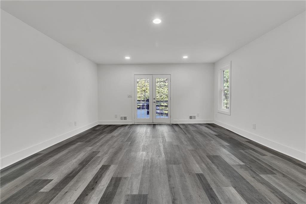5483 Wylstream Way Norcross, GA 30093 - Photo 16 of 56 an empty room with wooden floor and windows