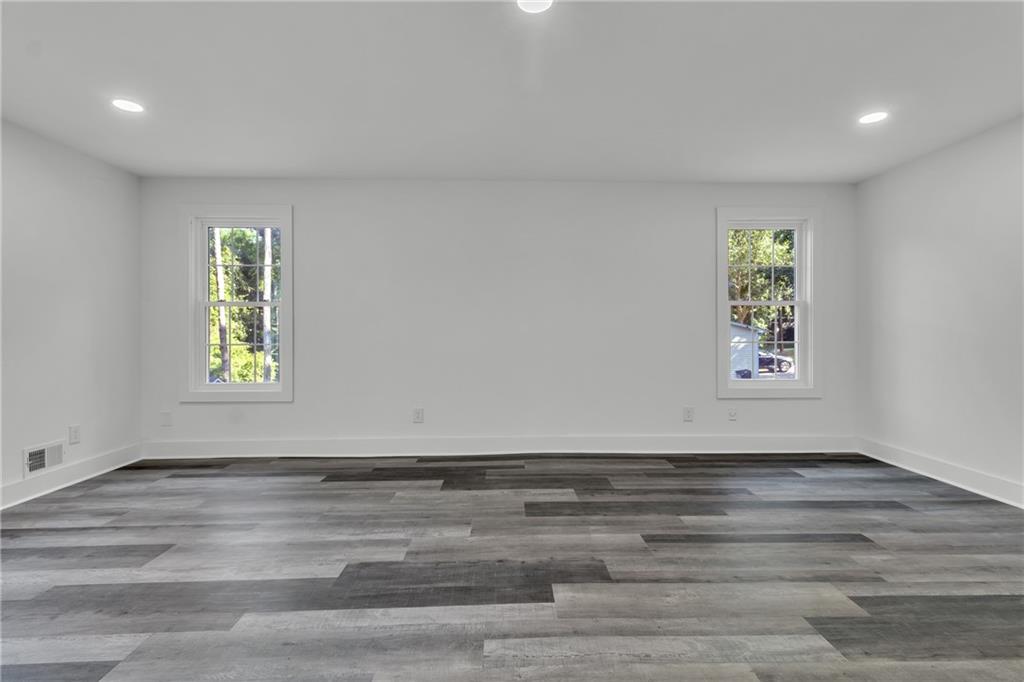 5483 Wylstream Way Norcross, GA 30093 - Photo 17 of 56 a view of an empty room with window and wooden floor