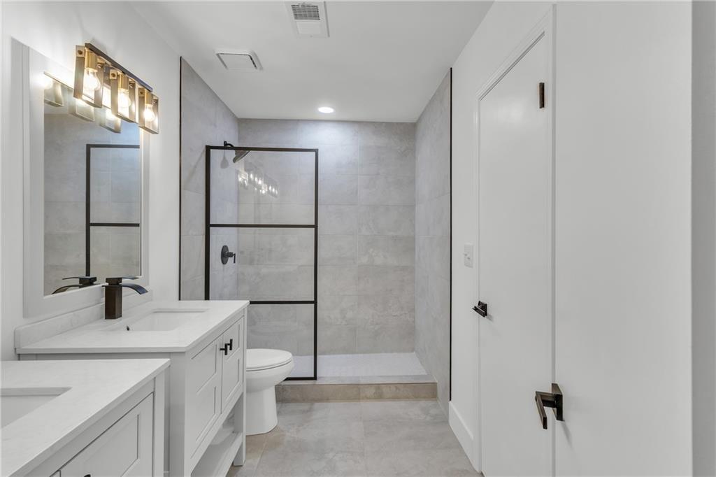 5483 Wylstream Way Norcross, GA 30093 - Photo 27 of 56 a bathroom with a double vanity sink toilet and shower