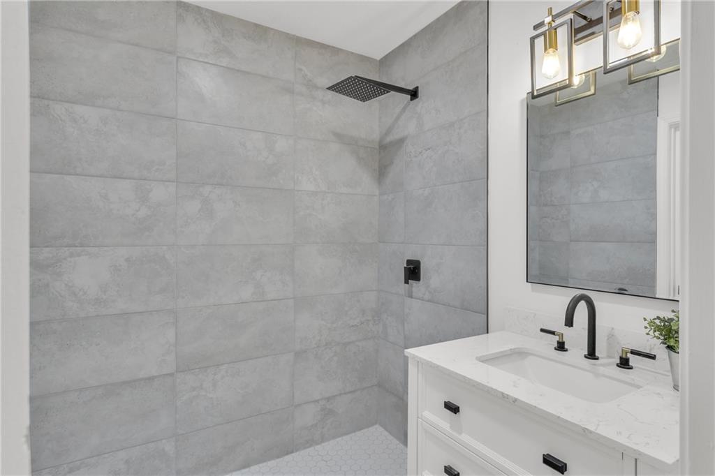 5483 Wylstream Way Norcross, GA 30093 - Photo 31 of 56 a bathroom with a sink a mirror and shower