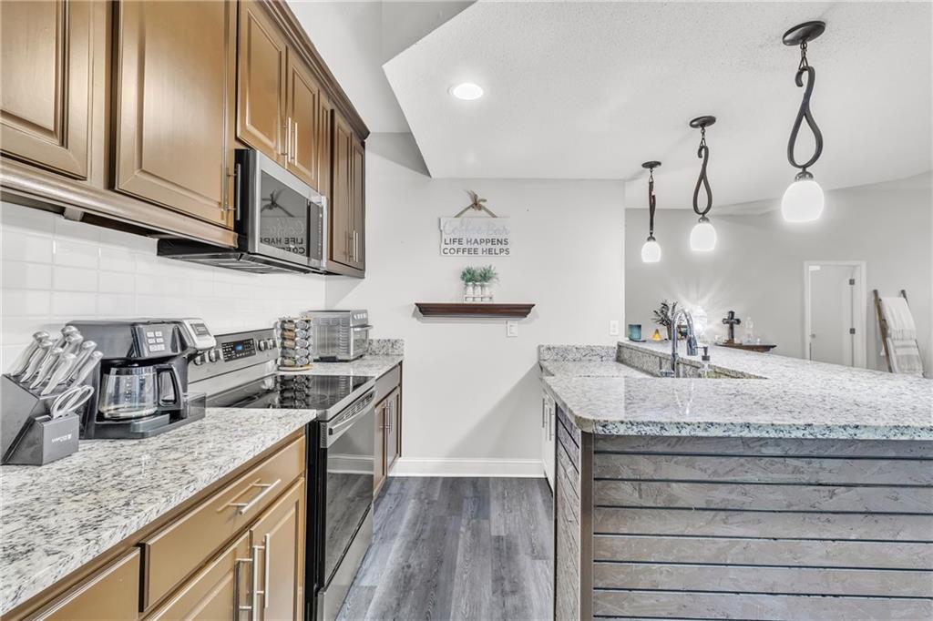 5483 Wylstream Way Norcross, GA 30093 - Photo 38 of 56 a kitchen with stainless steel appliances granite countertop a sink a stove and cabinets