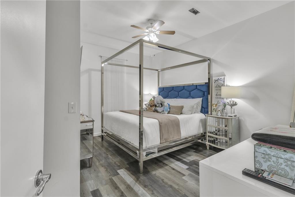 5483 Wylstream Way Norcross, GA 30093 - Photo 46 of 56 a bedroom with a bed and a chandelier