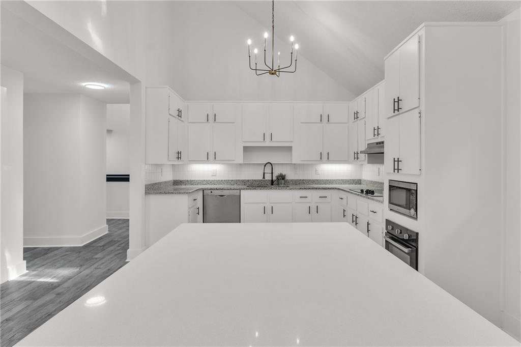 5483 Wylstream Way Norcross, GA 30093 - Photo 6 of 56 a kitchen with kitchen island a sink stainless steel appliances and white cabinets