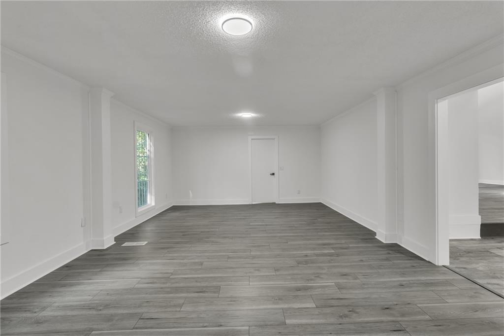 5483 Wylstream Way Norcross, GA 30093 - Photo 9 of 56 an empty room with wooden floor and windows