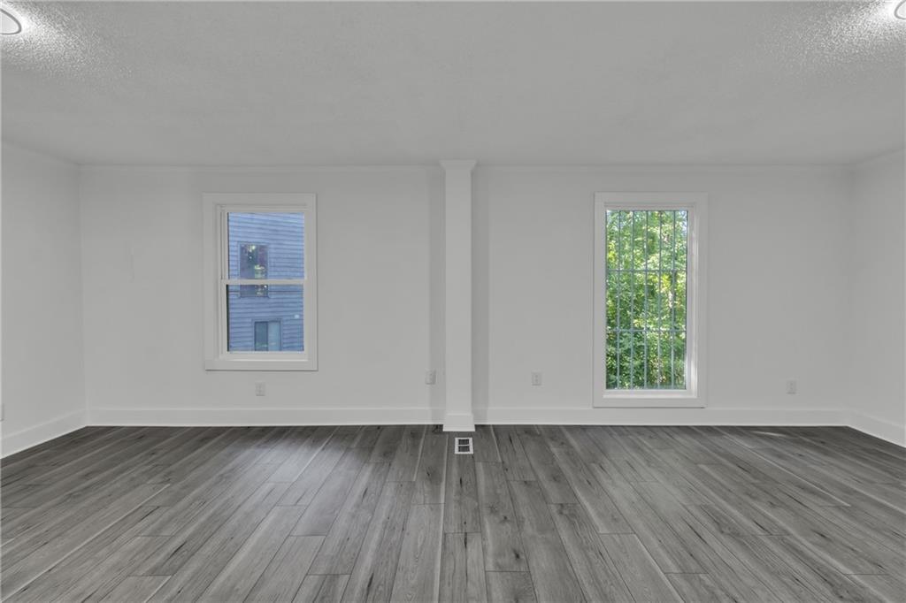 5483 Wylstream Way Norcross, GA 30093 - Photo 10 of 56 an empty room with wooden floor and window