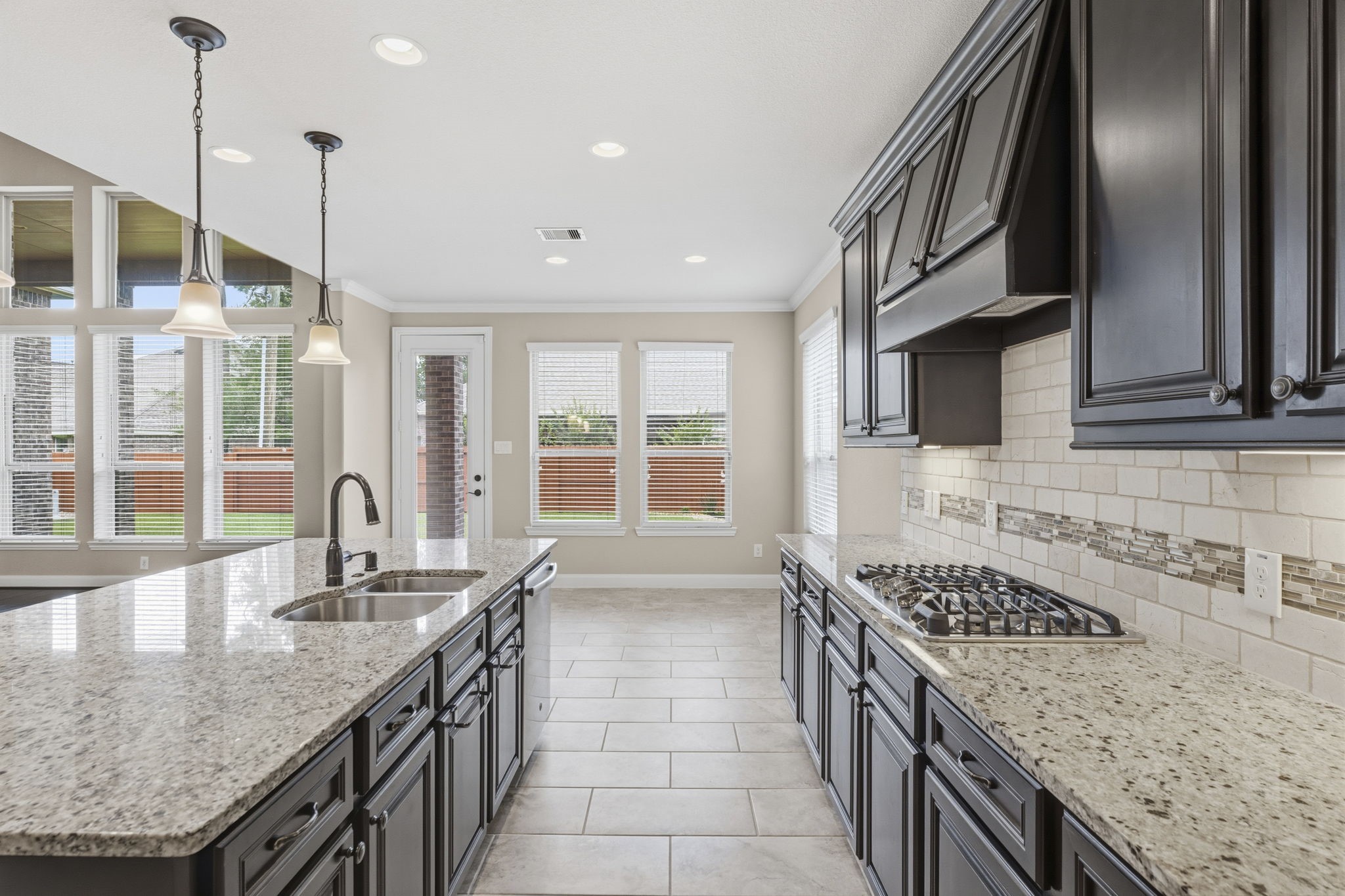 25210 Gaddis Oaks Drive Spring, TX 77389 - Photo 48 of 50 a kitchen with stainless steel appliances granite countertop a sink a stove and a wooden floor