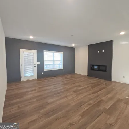 a big room with wooden floor and a window