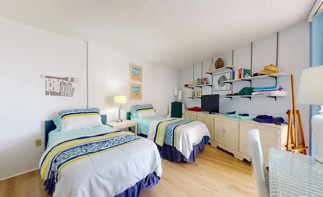 a bedroom with two beds and a desk