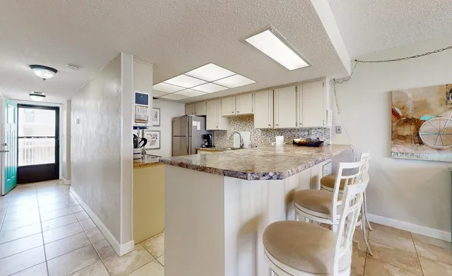 a kitchen with kitchen island granite countertop a sink cabinets and stainless steel appliances