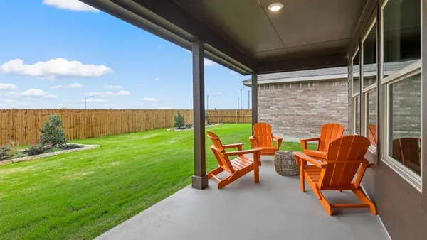 a backyard of a house with table and chairs