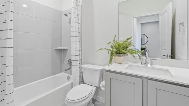 a bathroom with a sink a toilet a mirror a vanity a bathtub and shower