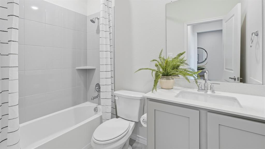 a bathroom with a sink a toilet a mirror a vanity a bathtub and shower